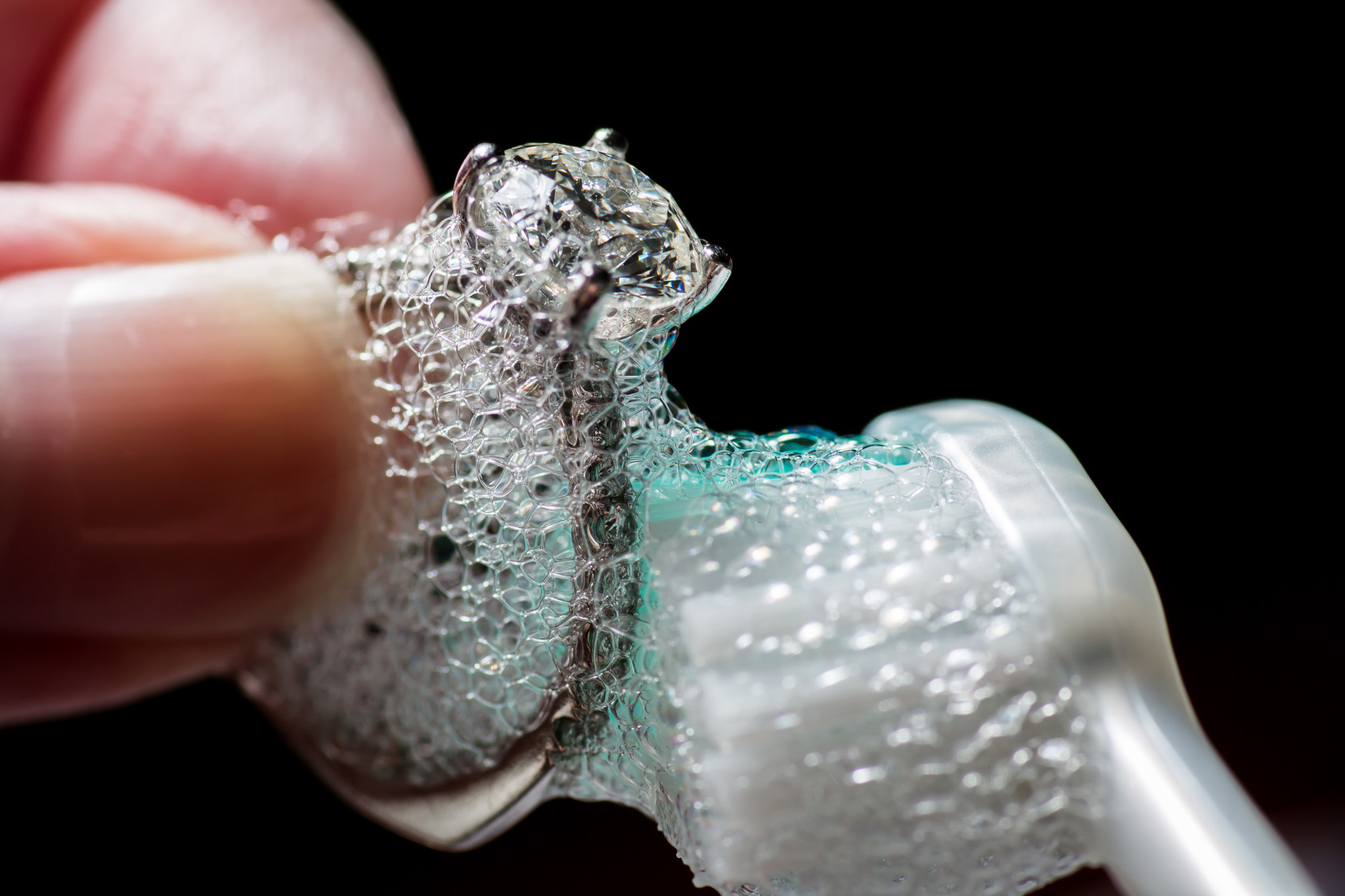 hands cleaning diamond jewelry