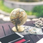 globe and money symbolizing travel expenses