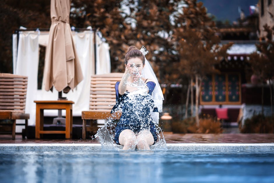 woman sitting on edge of swimming pool