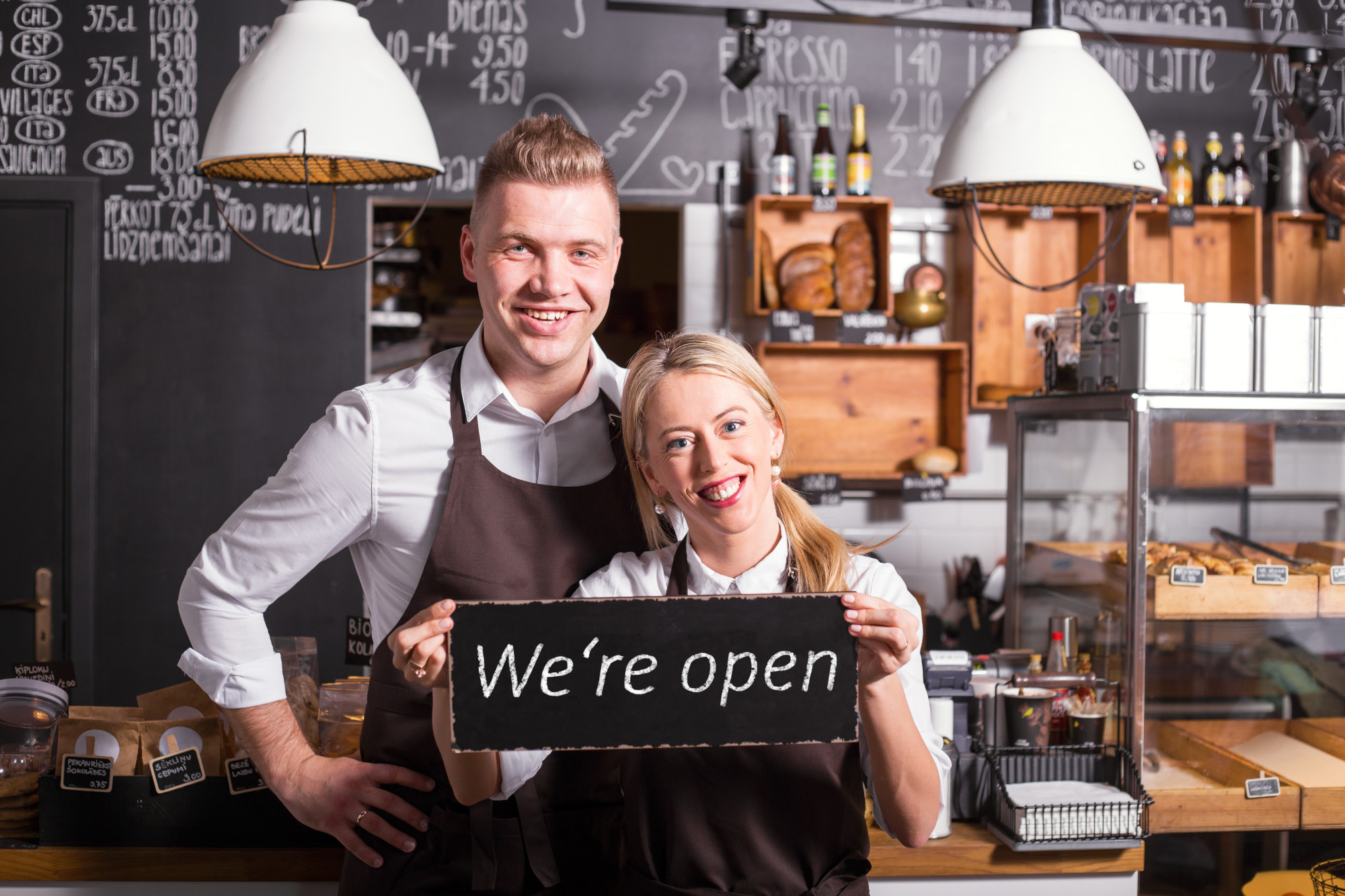 business owners with open sign