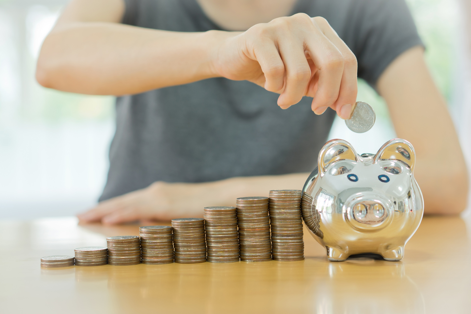 Home Financing Demonstrated by Putting Coins in a Piggy Bank